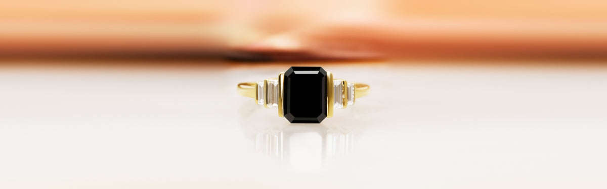 Noir Desir black emerald-cut diamond engagement ring in yellow gold with baguette side stones
