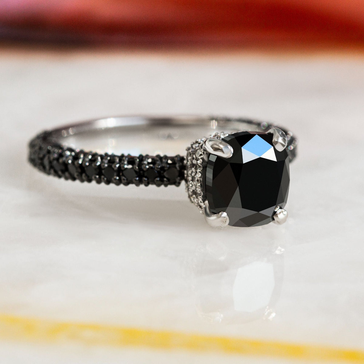 Black Magic cushion cut natural black diamond engagement ring with a black diamond pave band in white gold