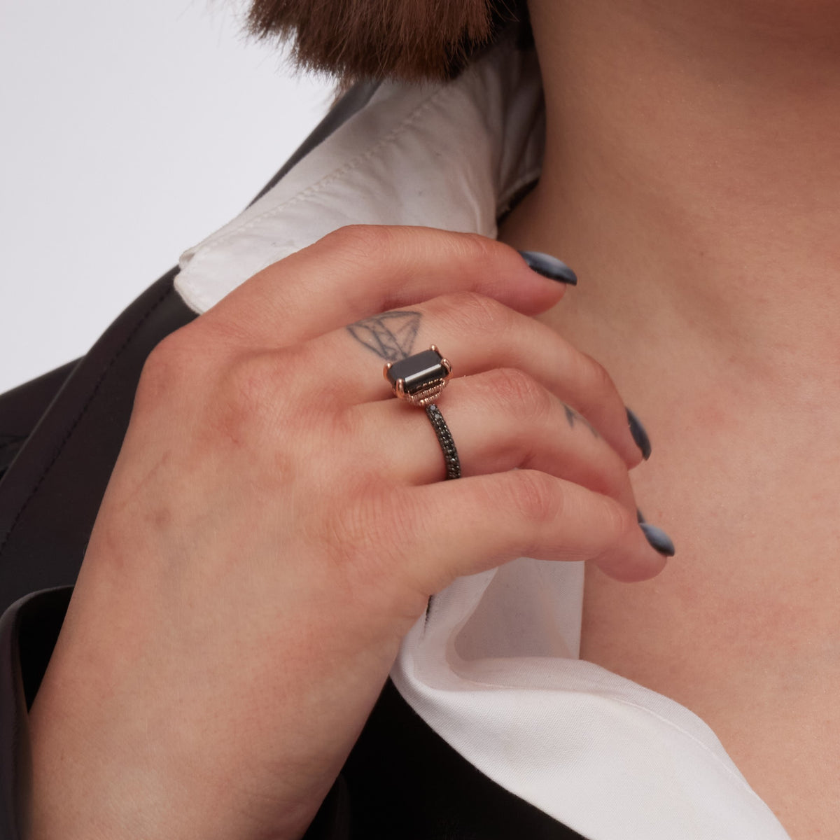 Oscura Magia emerald cut black diamond ring with a white shirt and black jacket
