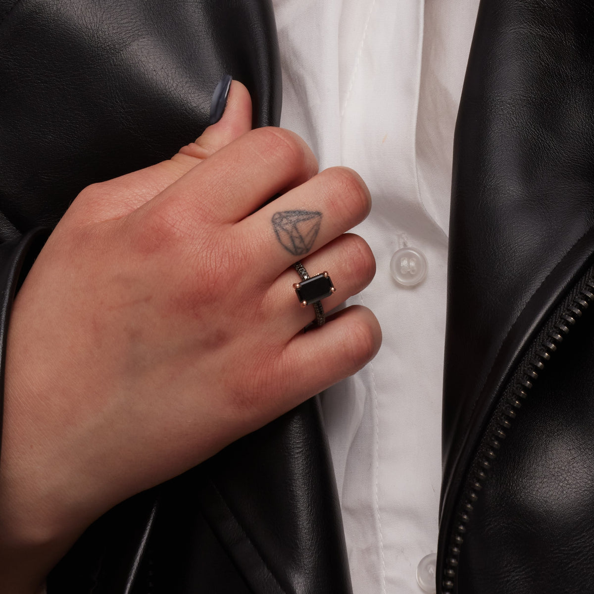 Oscura Magia black diamond ring worn with a leather jacket, side view