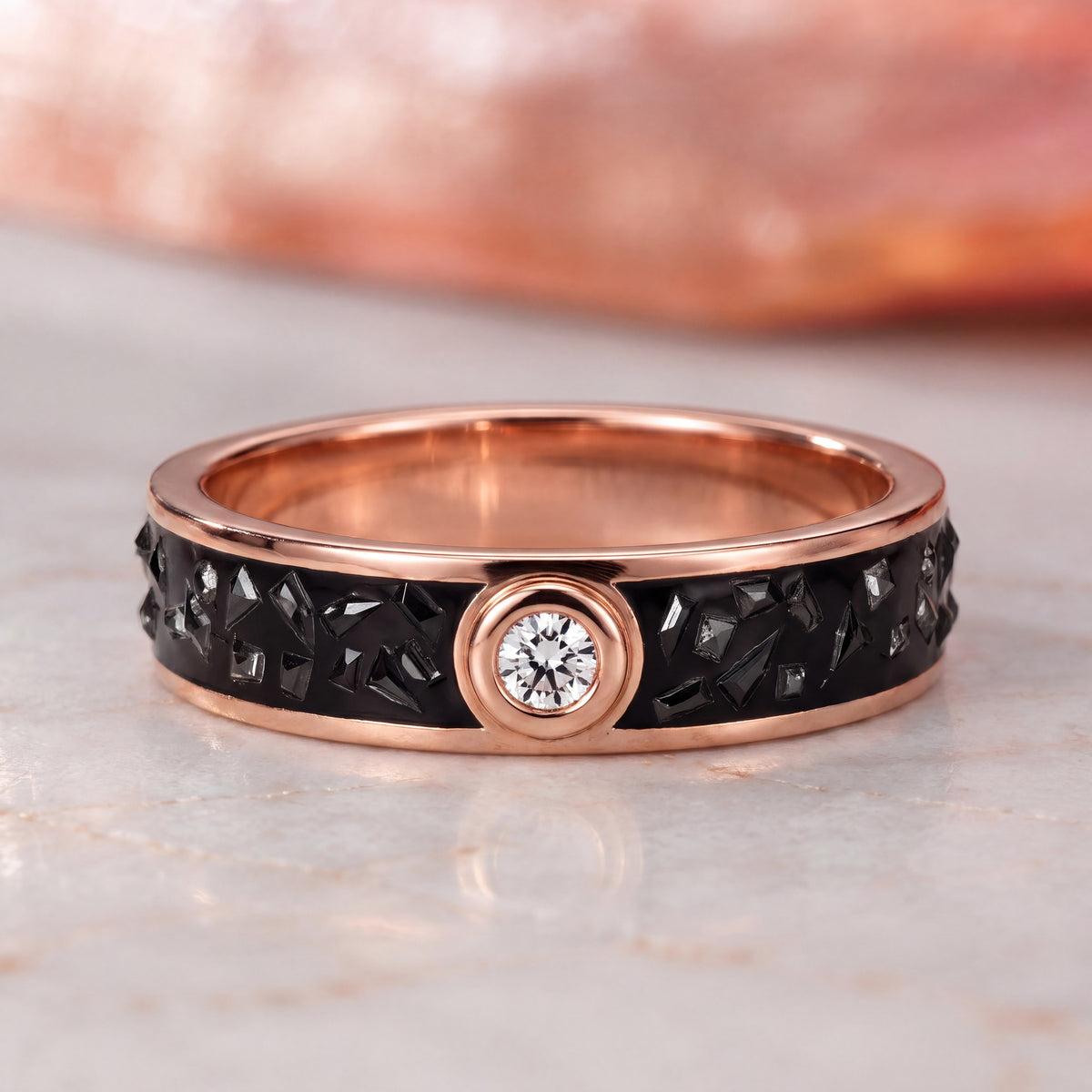 Accretion black diamond shard wedding band in rose gold, front view on marble