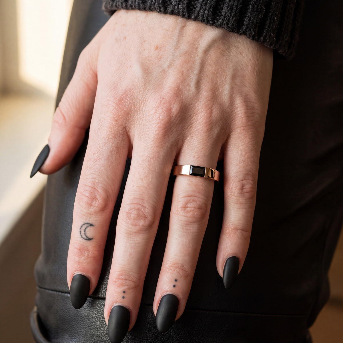Janus east-west baguette natural black diamond ring worn on the hand in rose gold