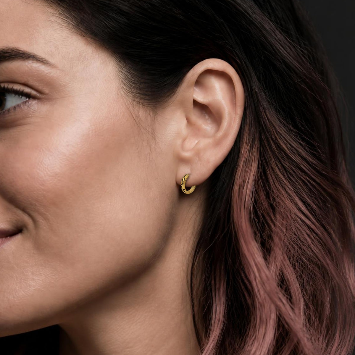Kintsugi huggie earring in yellow gold, worn, close-up on the ear