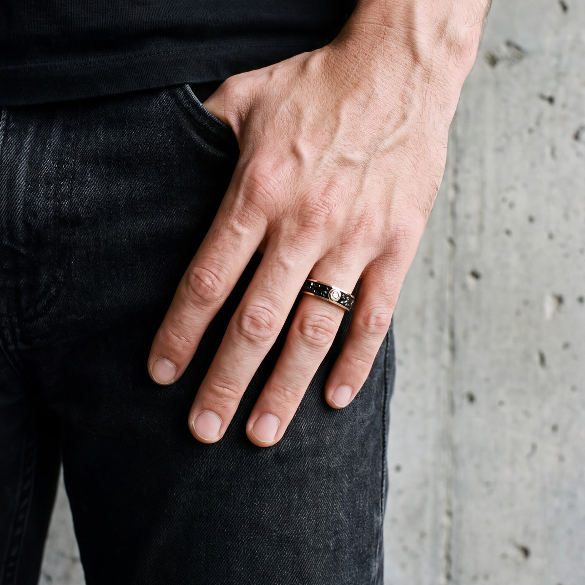 Rose gold black diamond men's band, hand at the pocket of black jeans
