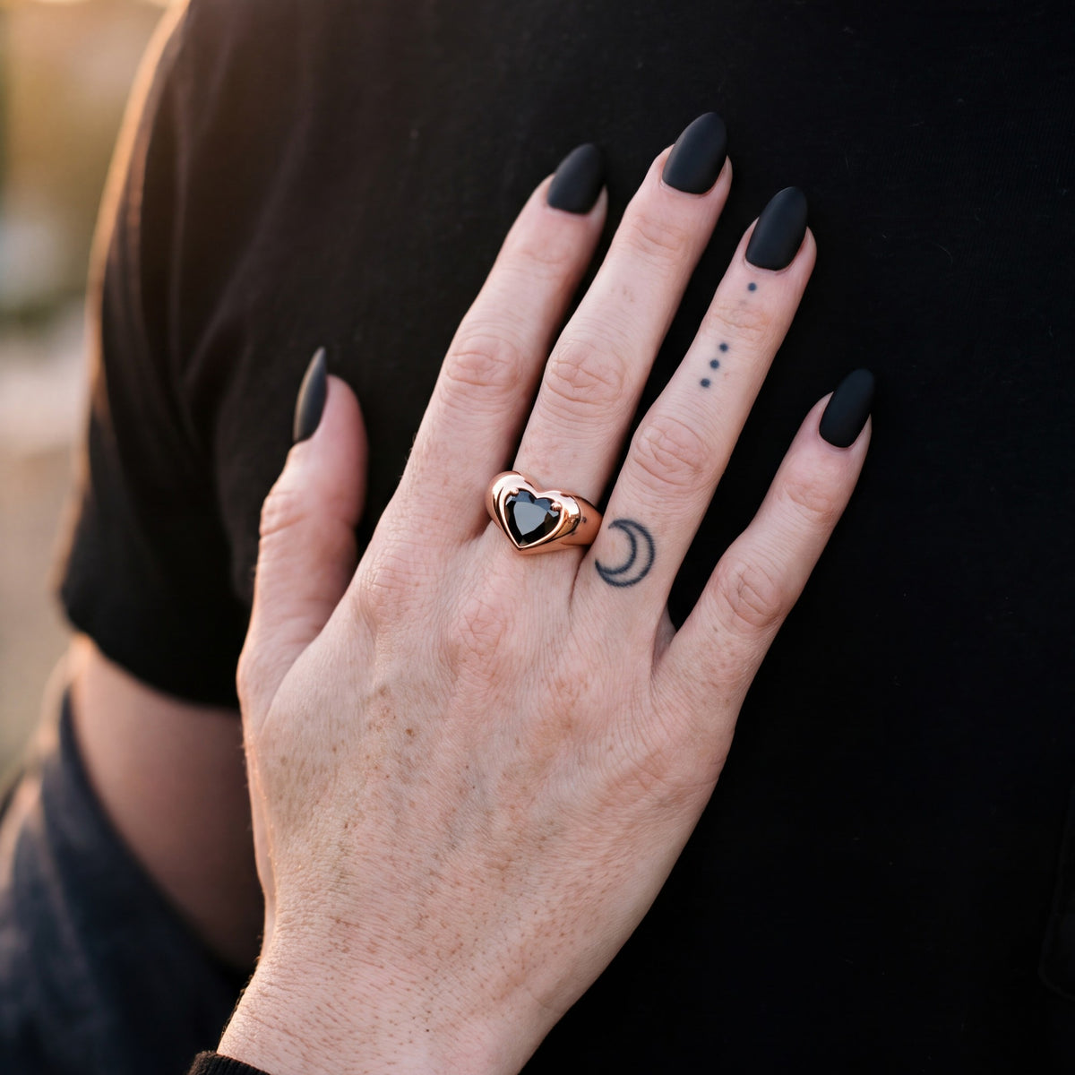Cor Caroli heart natural black diamond bezel ring in rose gold, her hand on her partner's chest