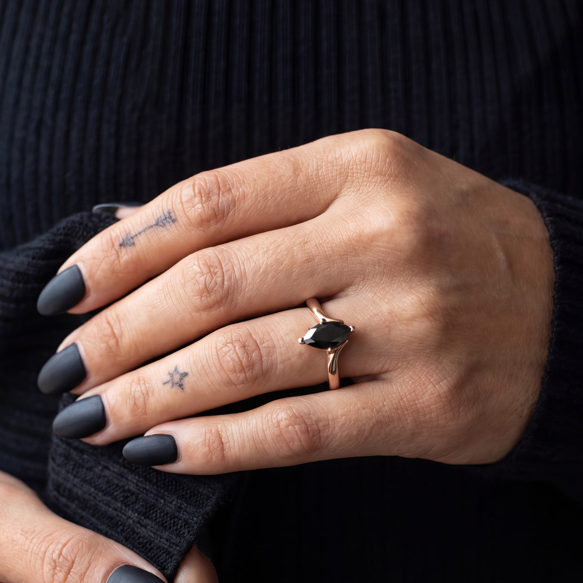 Phoenix marquise natural black diamond ring in rose gold, pushing up a knit sleeve