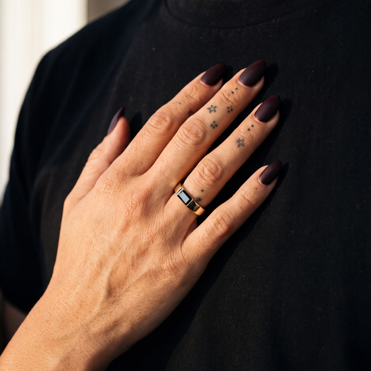 Janus east-west baguette natural black diamond ring in yellow gold, her hand on her partner's chest
