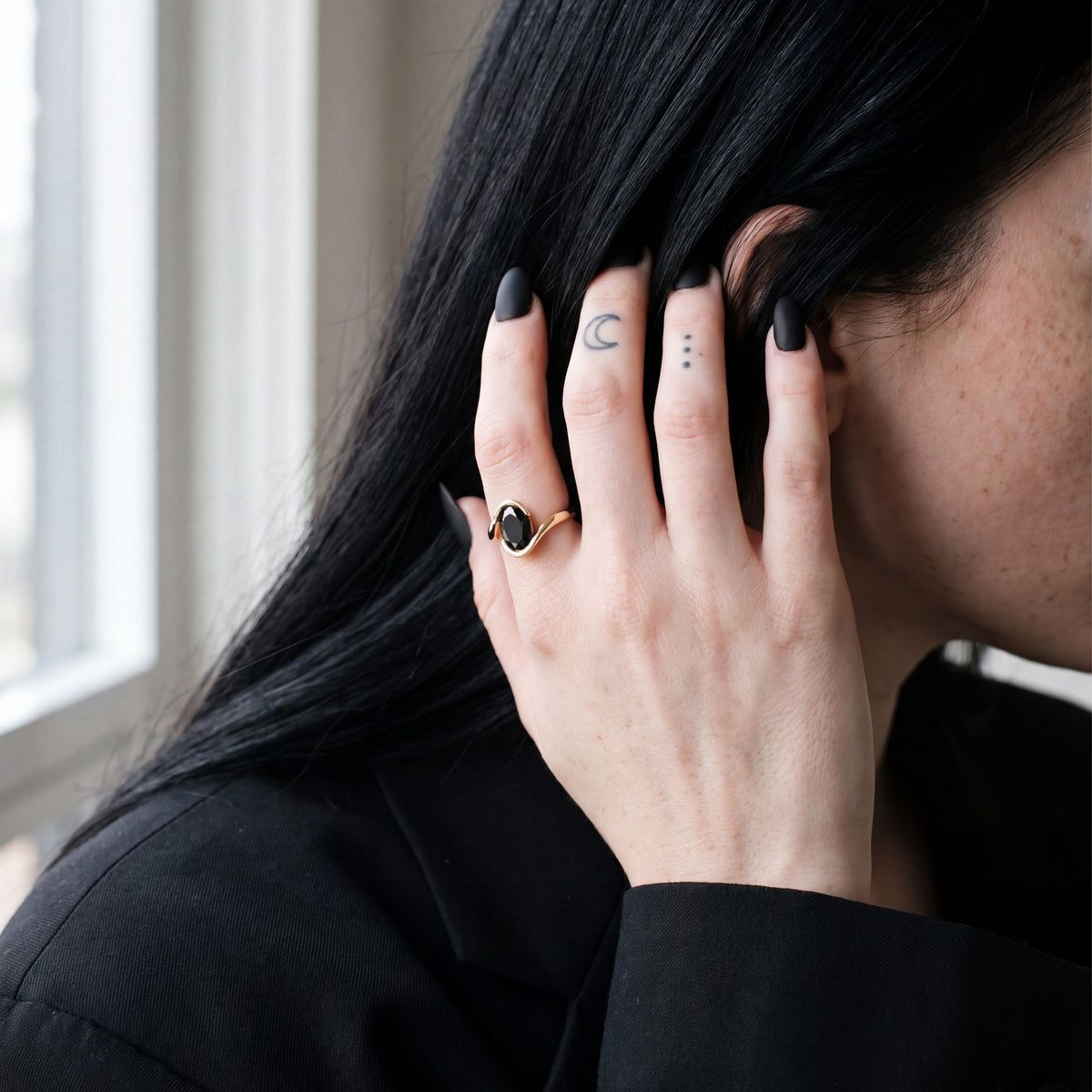 Selkie bypass oval natural black diamond engagement ring in yellow gold, her hand in her hair