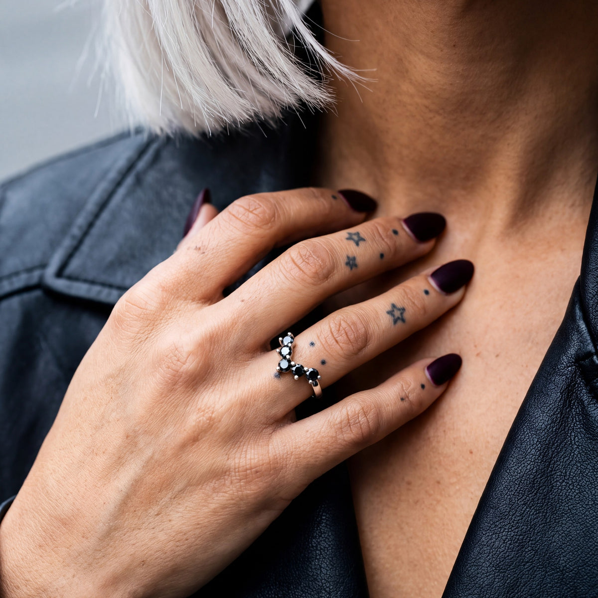 Hyades chevron natural black diamond contour band in white gold, her hand at a leather jacket collar