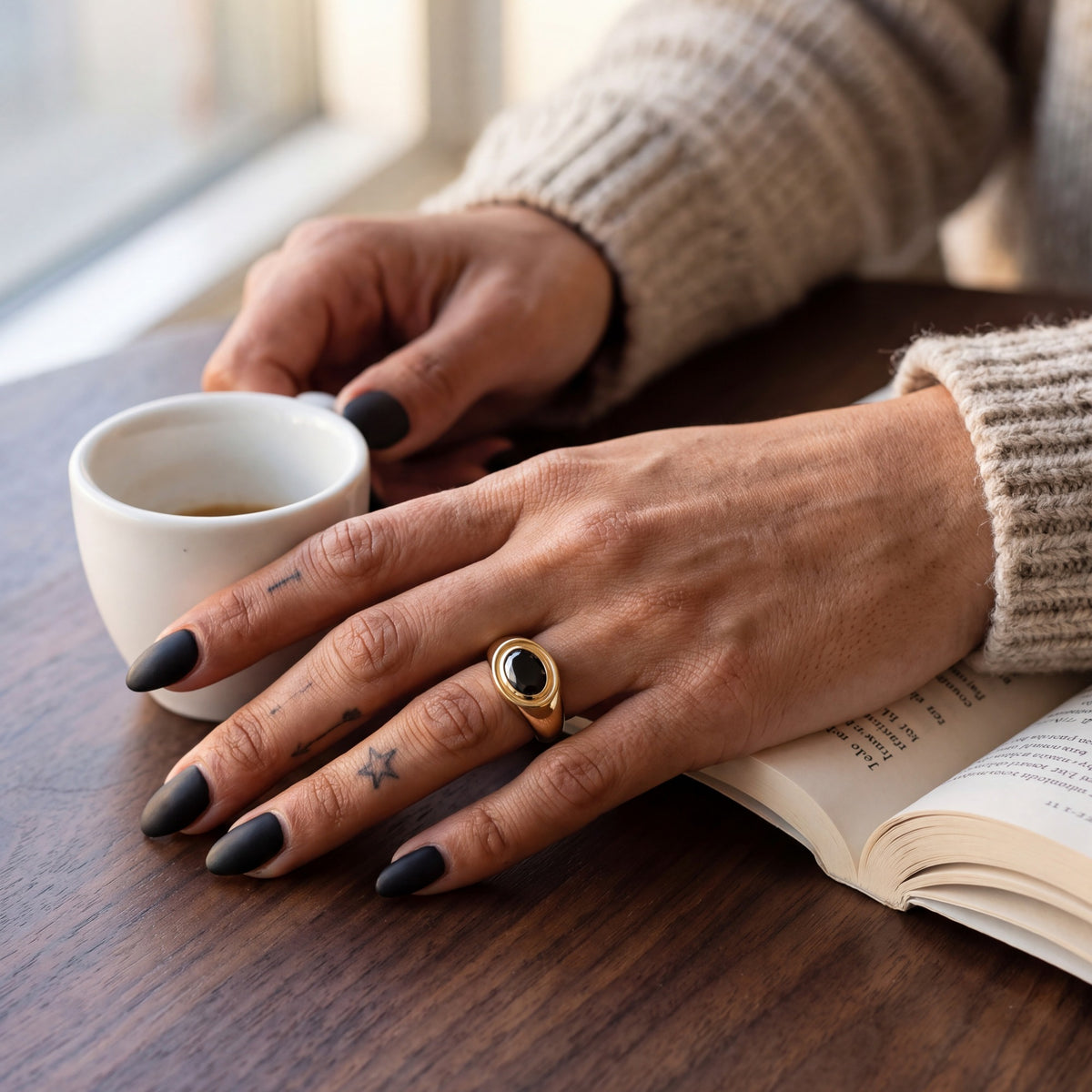 Algol east-west oval natural black diamond bezel ring worn on the hand in yellow gold