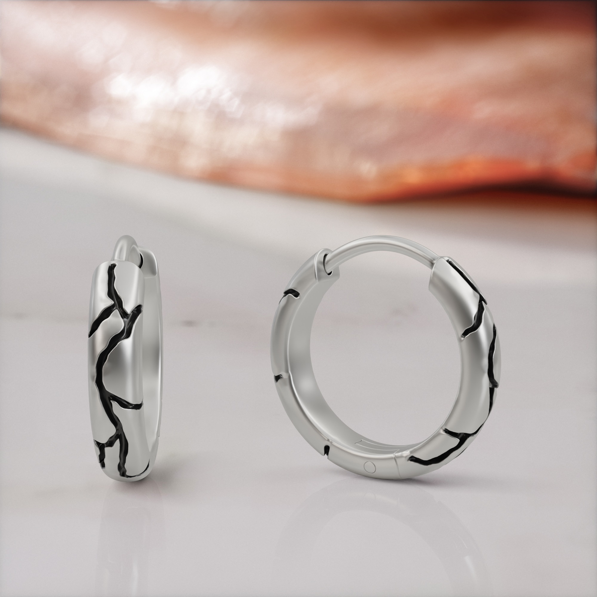 Kintsugi huggie earrings in white gold, the pair, black enamel seams across the band