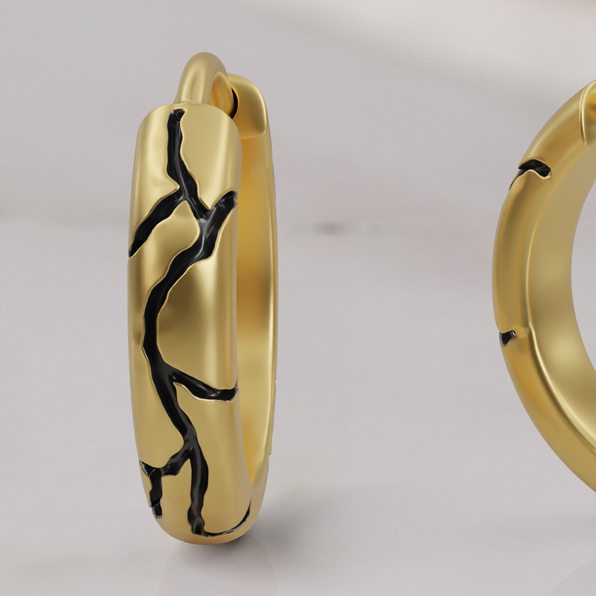 Kintsugi huggie earring in yellow gold, detail of the black enamel seams