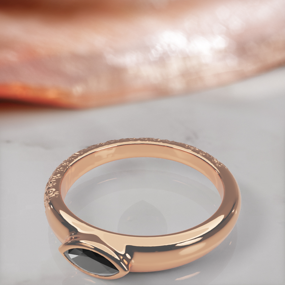 Disturbed engagement ring in rose gold, close-up of the bezel-set marquise black diamond and the hammered texture