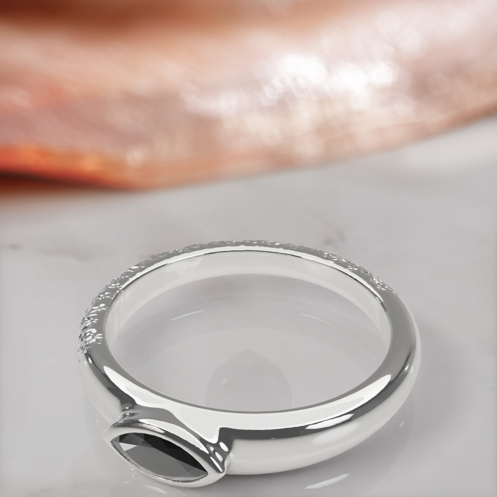 Disturbed engagement ring in white gold, close-up of the bezel-set marquise black diamond and the hammered texture